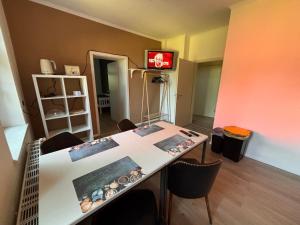 a room with a table with chairs and a television at Bahnhof Mulknitz in Forst
