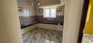 a bathroom with a marble floor and a window at Murugan Kudil in Mudukarai
