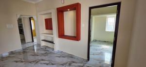a hallway with a mirror and marble floor at Murugan Kudil in Mudukarai