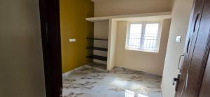 a hallway with a room with yellow walls and a window at Murugan Kudil in Mudukarai