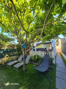 a hammock and chairs under a tree in a yard at Pavillon Clara Flor in Prades