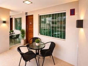 a dining room with a glass table and chairs at Flats Olinda Vista Mar in Olinda