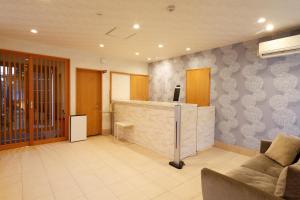 eine Lobby mit Theke und Sofa in der Unterkunft Shushu in Asago