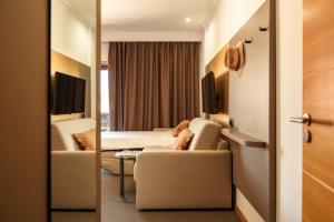 a hotel room with two beds and two chairs at Made Inn Entroncamento in Entroncamento