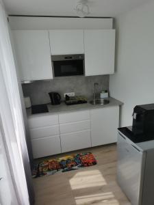 a kitchen with white cabinets and a sink at ArSa in Ventspils