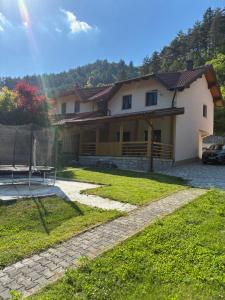 a house with a bench in front of it at Holiday House Ostrozac na Uni in Ostrožac