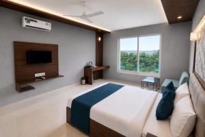a bedroom with a bed and a flat screen tv at Hotel H F at Assagao North Goa in Assagao