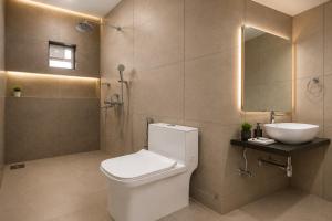 a bathroom with a toilet and a sink and a shower at Hotel H F at Assagao North Goa in Assagao