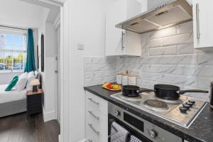 a kitchen with a stove with two pots on it at Nile - Cosy Studio Apartment by Traboule Properties Ltd in Warrington +14 photos