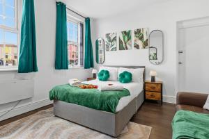 a bedroom with a bed with green pillows at Nile - Cosy Studio Apartment by Traboule Properties Ltd in Warrington