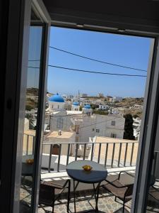 a balcony with a table and chairs and a view at Aurelia Rooms in Ios Chora