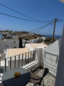 a table and chairs on a balcony with a view at Aurelia Rooms in Ios Chora