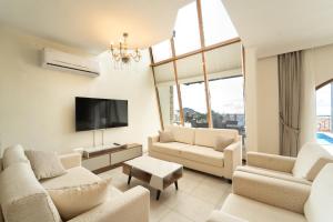 a living room with white furniture and a flat screen tv at Villa Meltem in Kalkan +31 photos