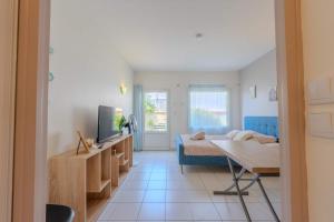 a living room with a bed and a tv and a couch at Appart-Hotel du drapeau bleu Residence Kiwi in Aytré
