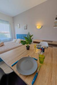 a wooden table with a plate on top of it at Appart-Hotel du drapeau bleu Residence Kiwi in Aytré