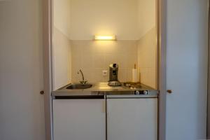 a small kitchen with a sink and a counter at Appart-Hotel du drapeau bleu Residence Kiwi in Aytré +22 photos