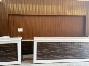 two white tables in front of a wooden wall at Seasons Resorts in Jabalpur