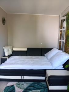 a large bed in a room with a couch at Kamienica Senator in Skierniewice