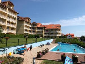 a large swimming pool with people in a resort at Furedi Apartman in Balatonfüred