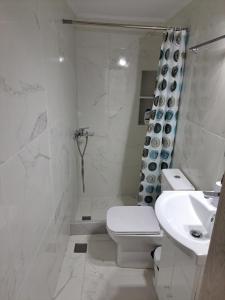 a white bathroom with a toilet and a sink at Patasa holiday apartment in Pyrgi +14 photos