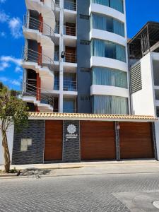 an apartment building with a garage in front of it at Mandala Rooms & Services in Arequipa