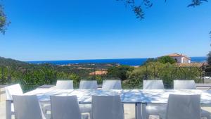 a table and chairs with a view of the ocean at Villa Esmerea Portocervo con Piscina privata ,Jacuzi e Sauna in Porto Cervo +66 photos