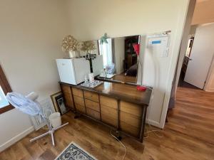 a kitchen with a dresser with a mirror and a refrigerator at Couchers de soleil à Sainte-Flavie in Sainte-Flavie