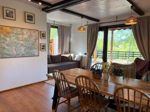 a living room with a wooden table and chairs at Sunset Mountains Village in Dealu Negru
