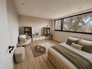 a bedroom with a large bed and a large window at Maison Unifamiliale in Theux