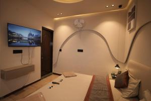 a room with a bed and a flat screen tv at L'Elegant Resort in Chail