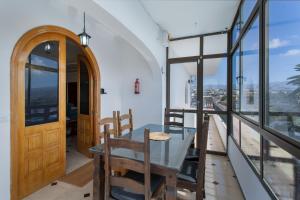 a dining room with a glass table and some windows at Villa Jomeca in Salobre