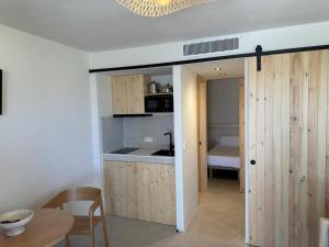 a kitchen with a door leading to a bedroom at Apartamentos Eugenio by Formentera Passport in La Savina