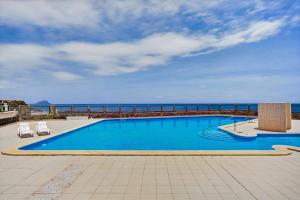 a swimming pool with the ocean in the background at Atlantic Penthouse Retreat in Costa Del Silencio