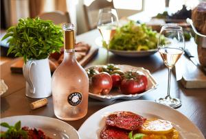 a table with plates of food and a bottle of wine at Appartement Lueur Locale in Correns +24 photos