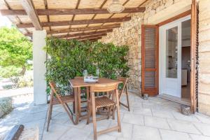 a wooden table and chairs on a patio at Borgo del Sole Salento in Torre Vado