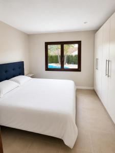 a bedroom with a large white bed and a window at Casa Lluna De Mar in L'Ampolla +8 photos