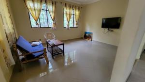 a living room with a blue chair and a tv at WamkHouse in Jambiani