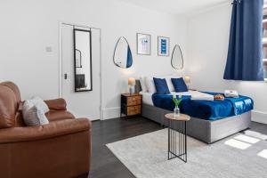 a bedroom with a bed and a couch and a table at Tigris - Cosy Studio Apartment by Traboule Properties Ltd in Warrington