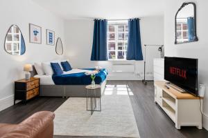 a living room with a bed and a tv at Tigris - Cosy Studio Apartment by Traboule Properties Ltd in Warrington