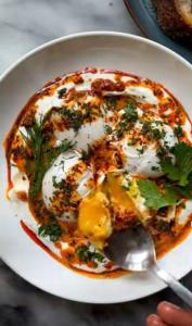 a plate of food with eggs and herbs on it at WamkHouse in Jambiani