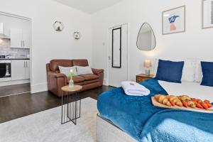 a bedroom with a bed with a tray of food on it at Tigris - Cosy Studio Apartment by Traboule Properties Ltd in Warrington