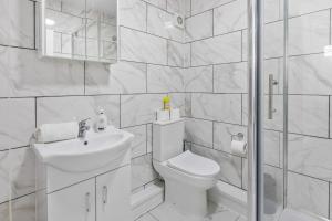 a white bathroom with a toilet and a sink at Tigris - Cosy Studio Apartment by Traboule Properties Ltd in Warrington