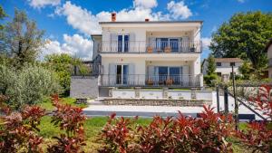 a large white house with a balcony at Villa Amoena with Pool and Sauna in Brtonigla