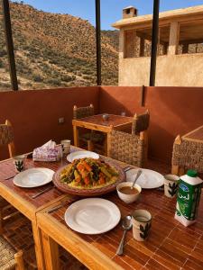 a wooden table with a plate of food on it at Yara Lodge in Tamraght Ou Fella +46 photos