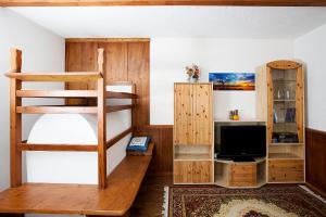 a room with a bunk bed and a tv at Hölzlhof in Brunico