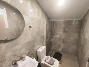 a bathroom with a sink and a toilet and a mirror at Savvas's Room in Nea Kallikrateia