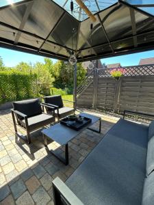 a patio with two couches and an umbrella at Emils Heidehaus in Soltau +12 photos