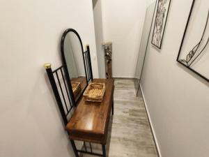 a hallway with a wooden table and a mirror at Savvas's Room in Nea Kallikrateia