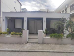 a white house with potted plants in front of it at Savvas's Room in Nea Kallikrateia