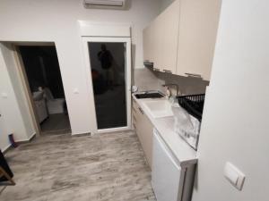 a white kitchen with a sink and a counter at Savvas's Room in Nea Kallikrateia